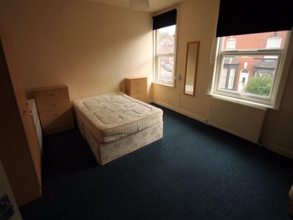 A simple, tidy bedroom featuring a large window...
