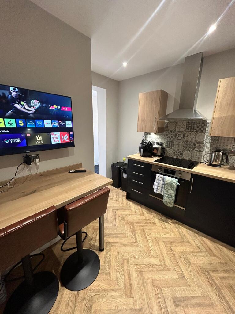 Modern kitchen with wooden countertops, a tiled...