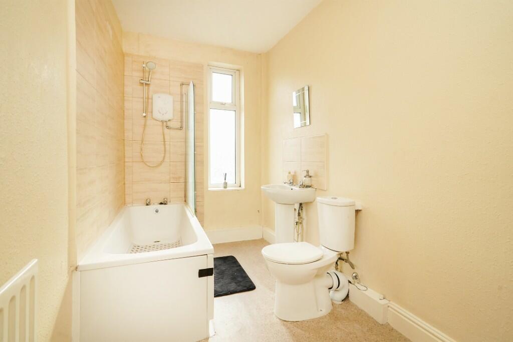 Bright and clean bathroom suite featuring a ful...