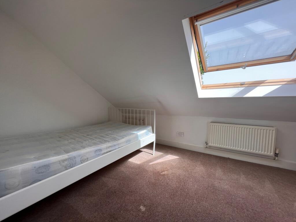 A bright and clean single bedroom featuring a w...
