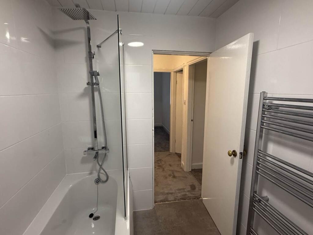 A clean and modern bathroom with a spacious sho...