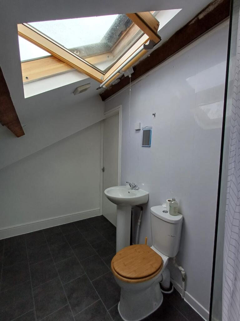 A modern, tidy bathroom with a toilet, sink, an...