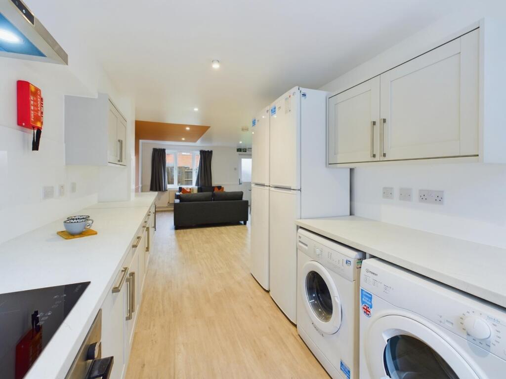 A spacious and modern kitchenette with ample st...