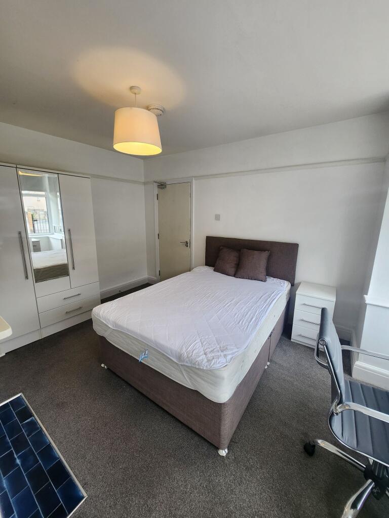 A clean and well-lit double bedroom featuring a...