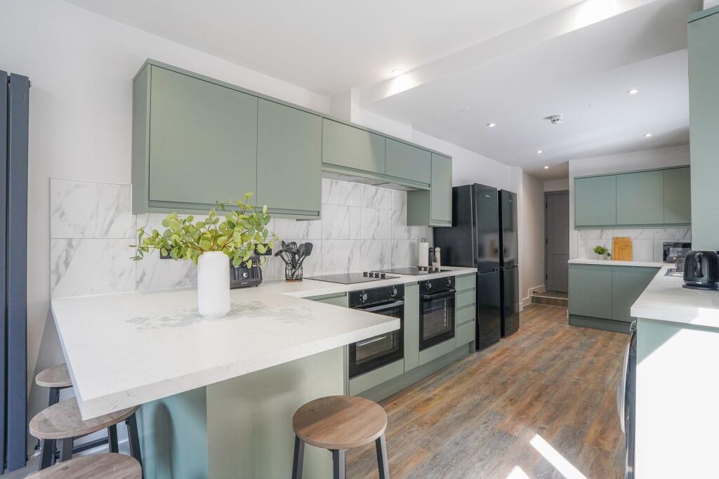Bright and modern kitchen featuring stylish gre...