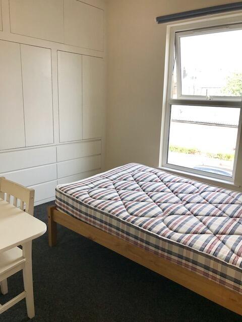 A bright and tidy single bedroom featuring a co...
