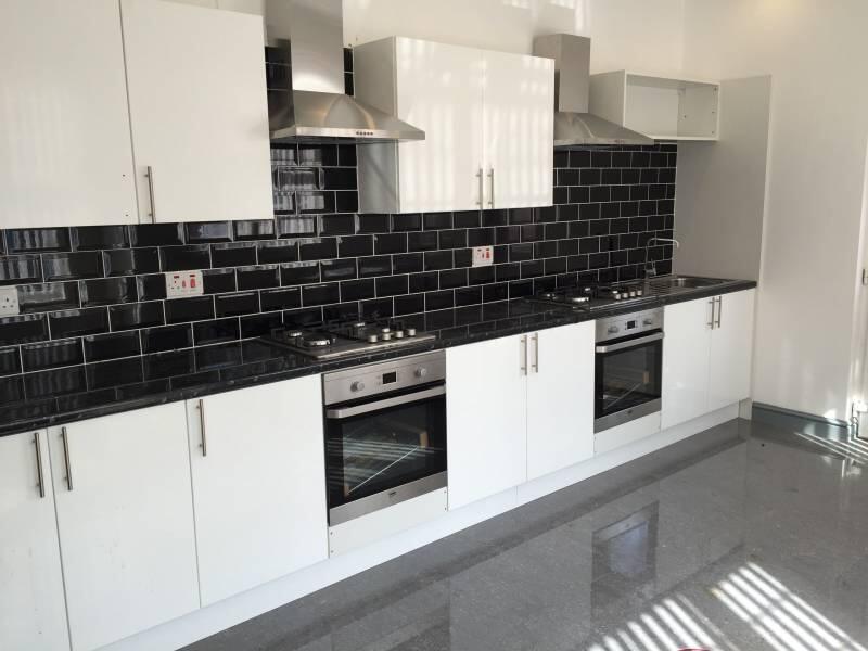 Modern galley-style kitchen with glossy white c...