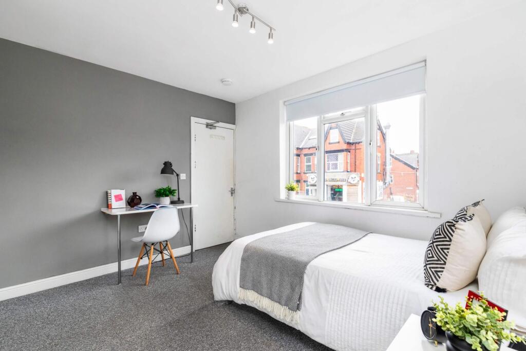 A bright and inviting bedroom featuring a comfo...