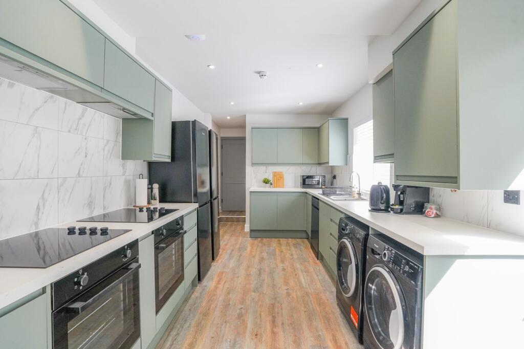 Bright and modern kitchen featuring sleek cabin...