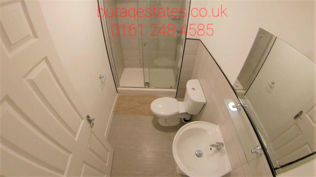 A clean and modern bathroom featuring a glass-e...