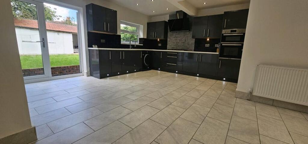 Spacious modern kitchen featuring sleek black c...