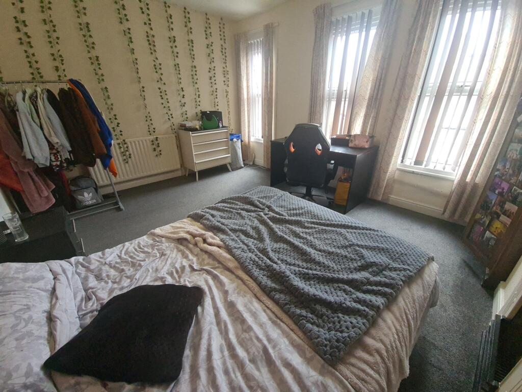 A spacious master bedroom featuring a comfortab...