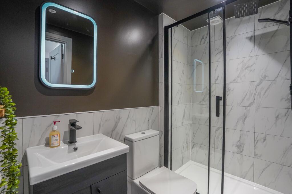 Modern bathroom with a sleek vanity unit, a lar...