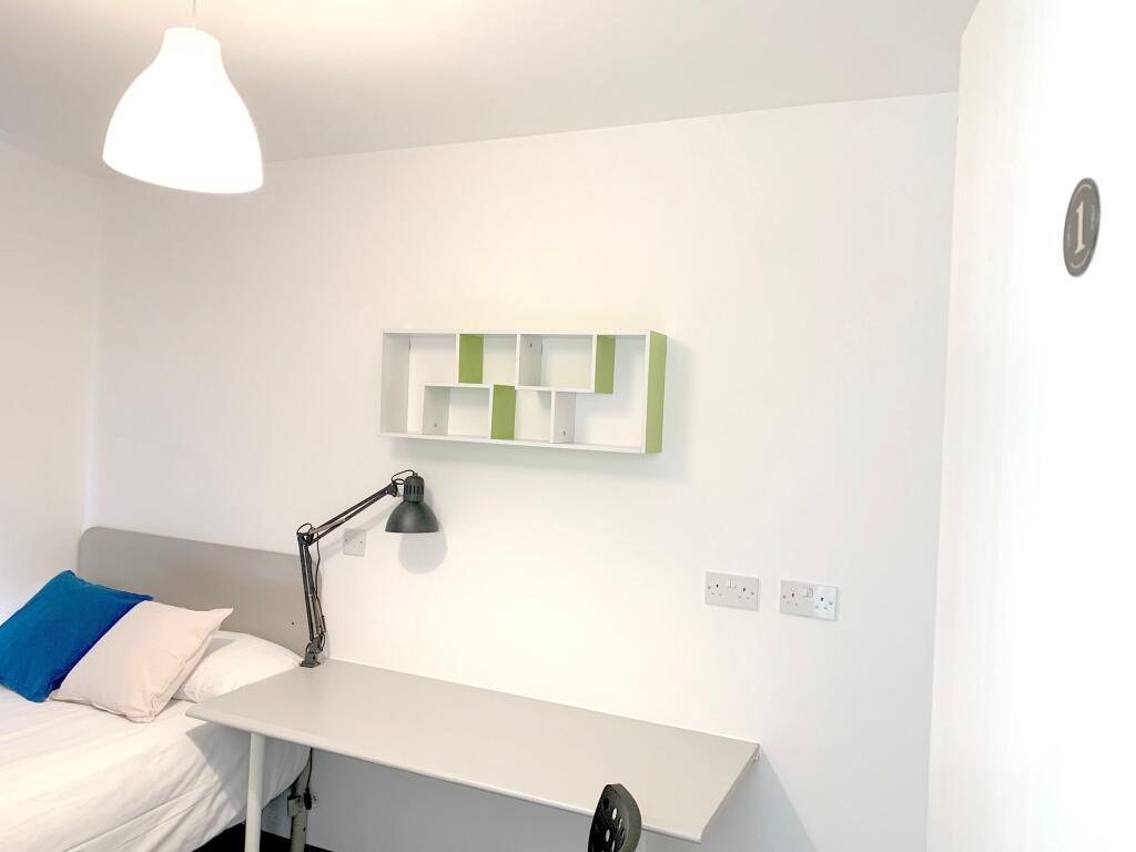 A tidy and minimalist single bedroom featuring ...