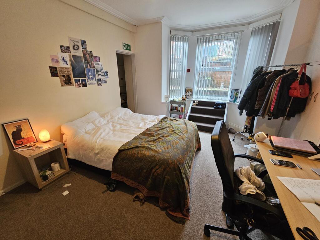 Cozy furnished bedroom with a double bed, bedsi...