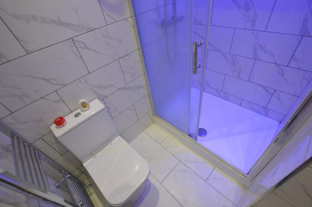 Modern bathroom featuring a shower with a blue ...