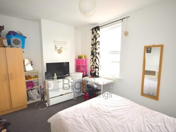 A bright and tidy single bedroom featuring a co...