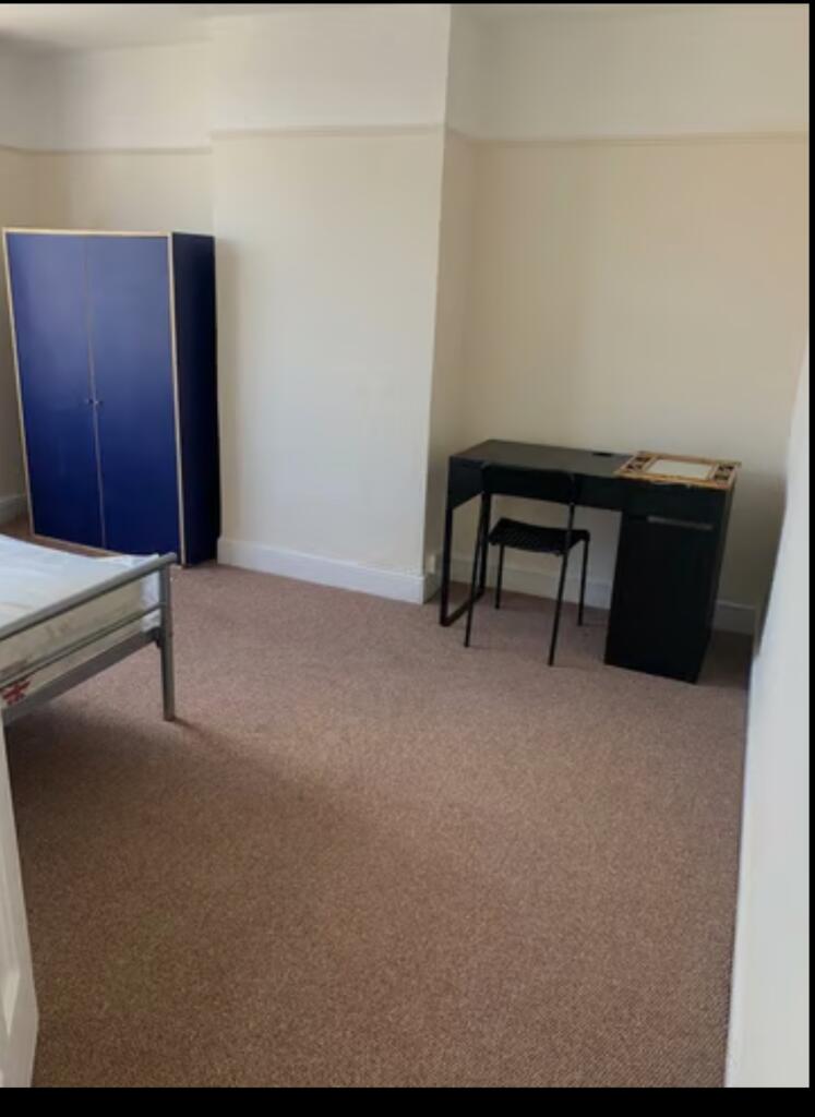 A spacious and clean double bedroom featuring a...