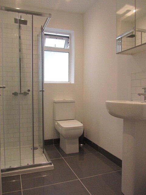 A modern bathroom featuring a glass-enclosed sh...