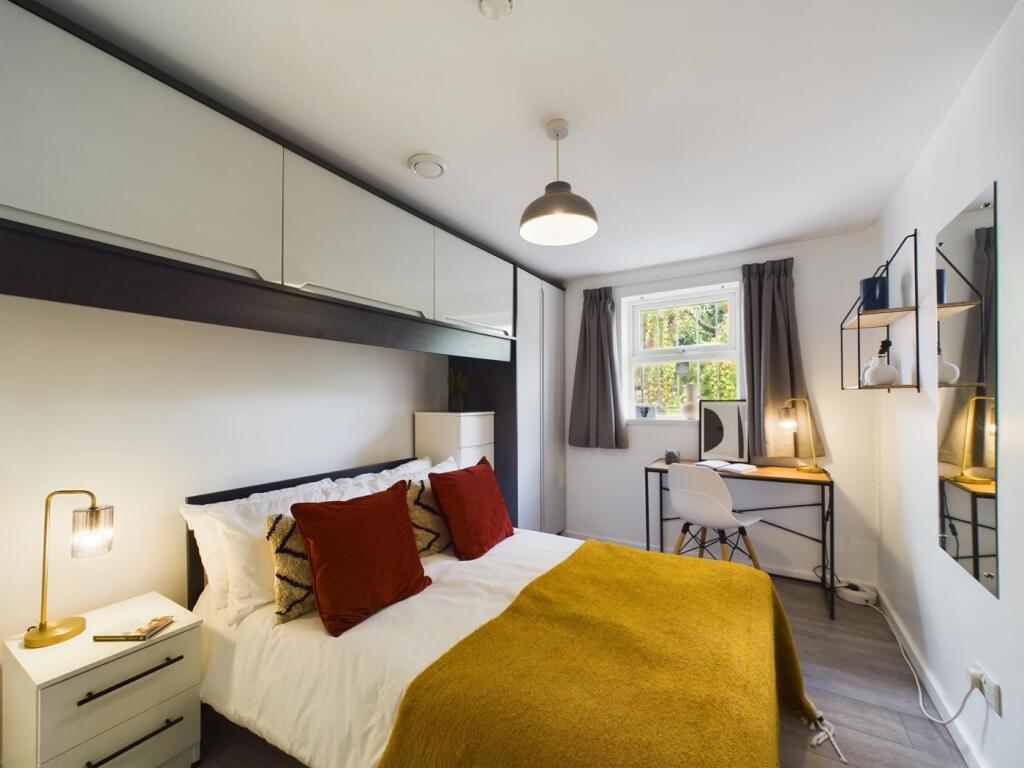 A bright and stylish double bedroom featuring a...