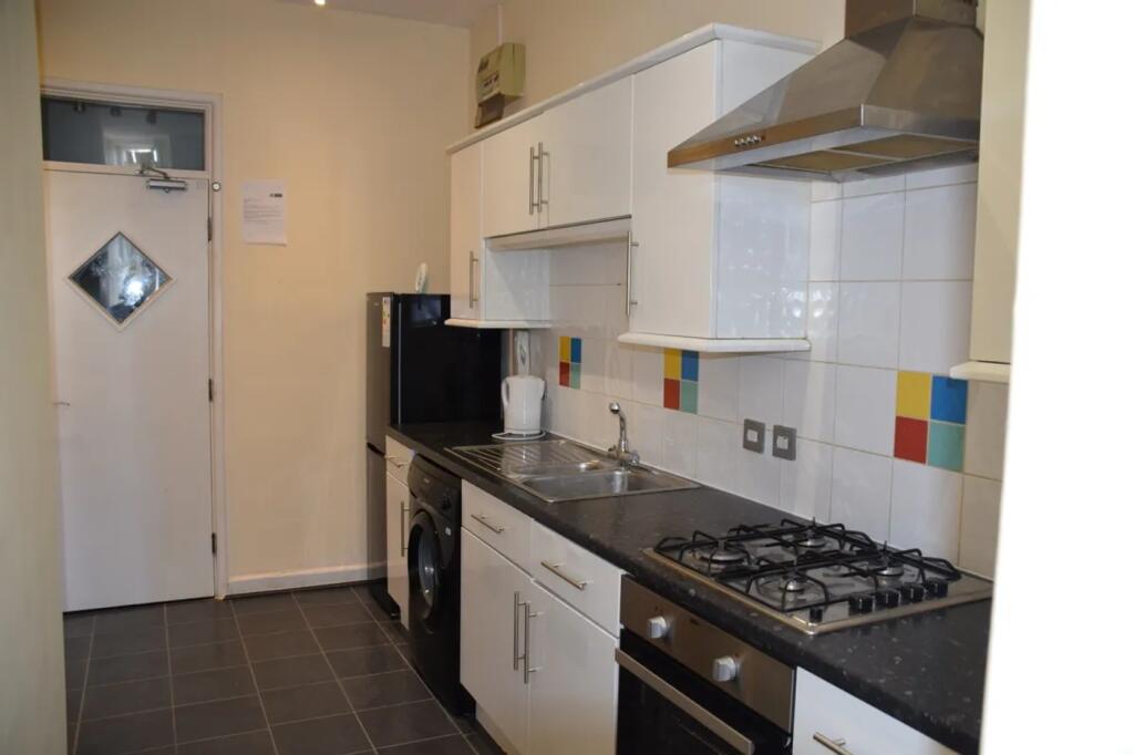 A modern and tidy kitchenette with ample storag...