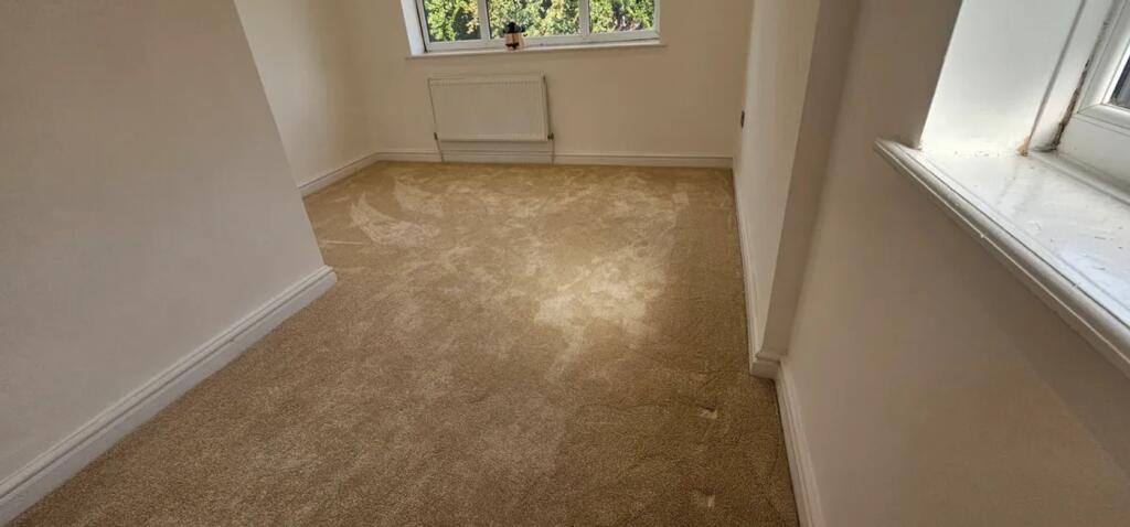 This inviting double bedroom features fresh car...