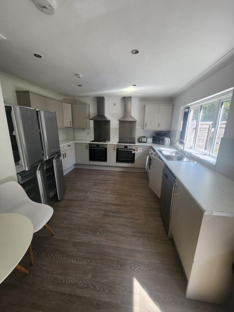 Modern kitchen with ample natural light, featur...