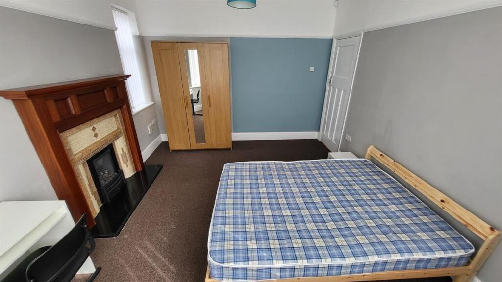 A well-maintained bedroom with a large bed, fea...