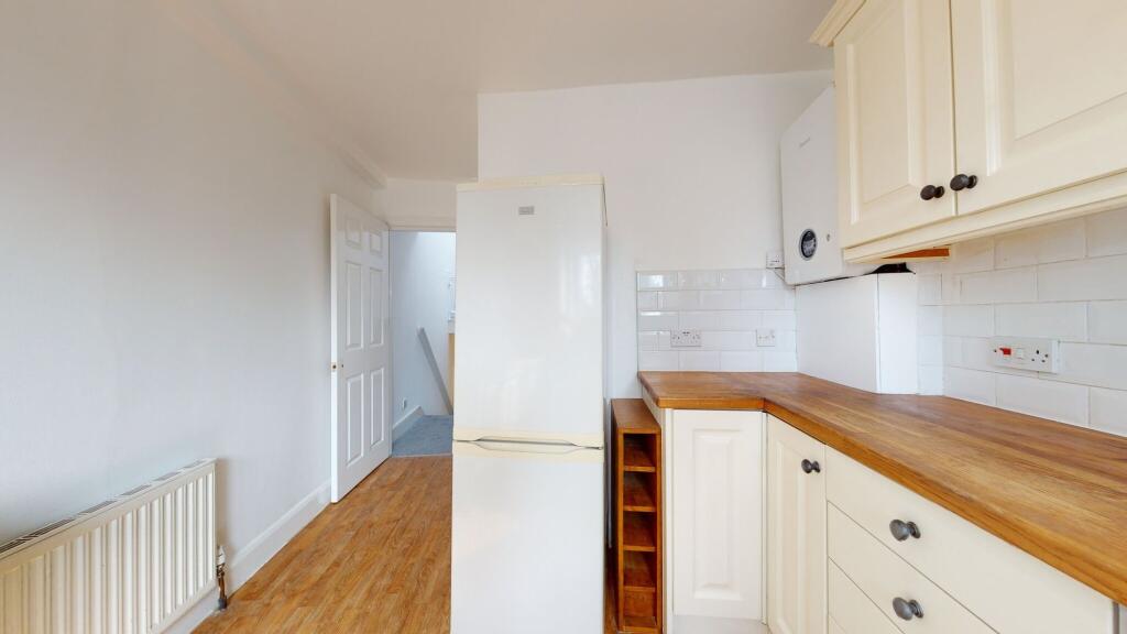 Bright and tidy kitchen featuring cream cabinet...
