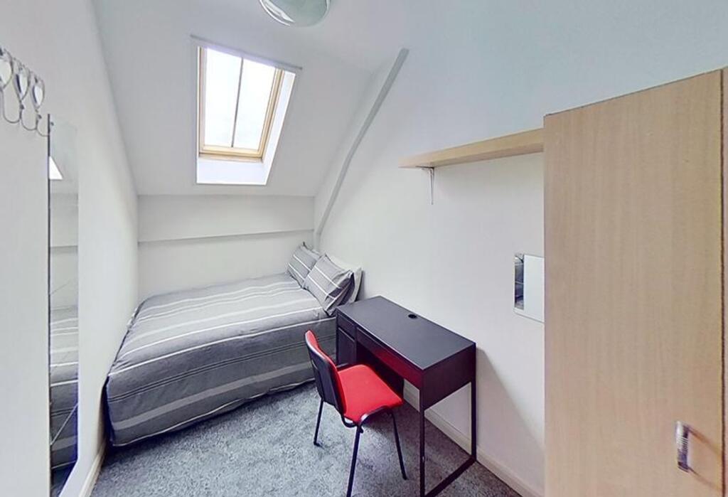 Cozy double bedroom featuring a comfortable bed...