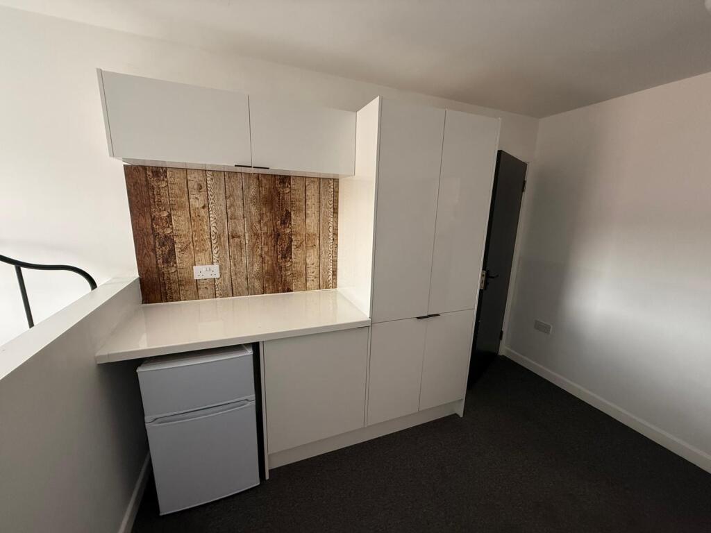 Modern kitchenette featuring sleek cabinetry an...