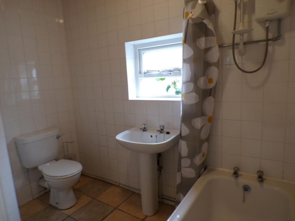 Bright and clean bathroom with a small window a...