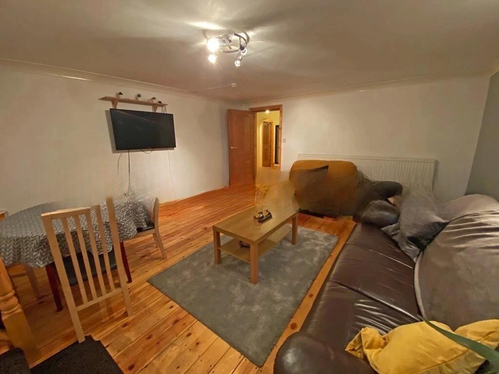 A cozy living room featuring wooden floors, com...