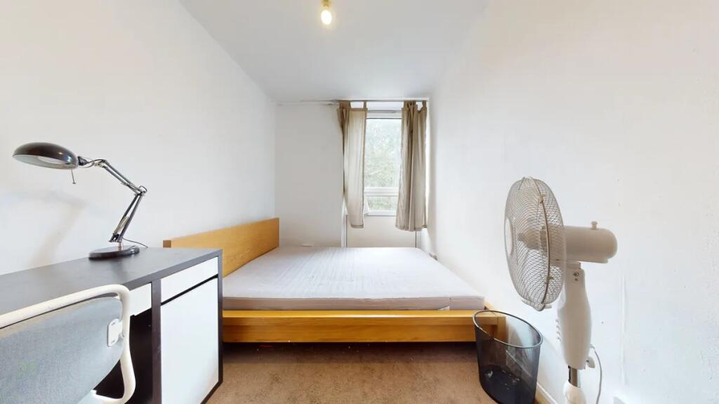 A well-lit double bedroom featuring a wooden be...
