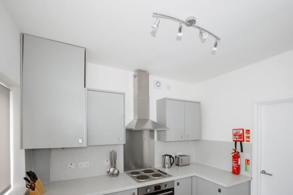 This modern kitchen features sleek grey cabinet...