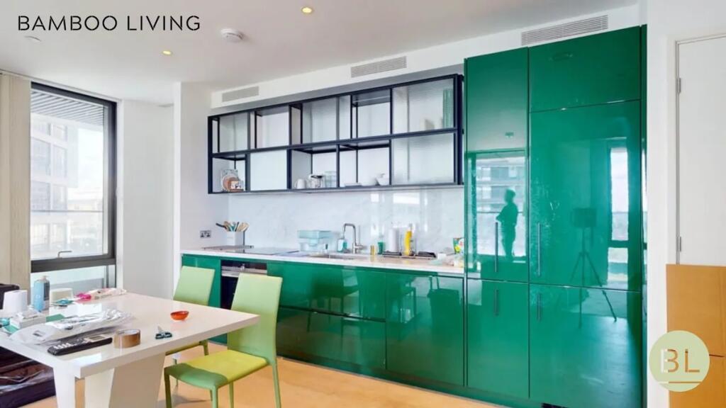 Bright and modern kitchen featuring glossy gree...