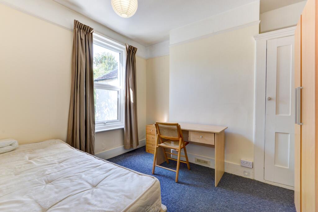 A bright and tidy single bedroom featuring a co...