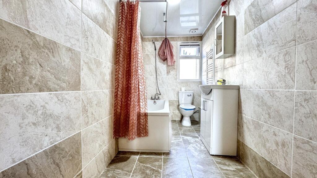 Bright and clean bathroom suite featuring a spa...