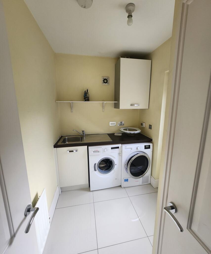 Bright and tidy laundry room featuring modern w...