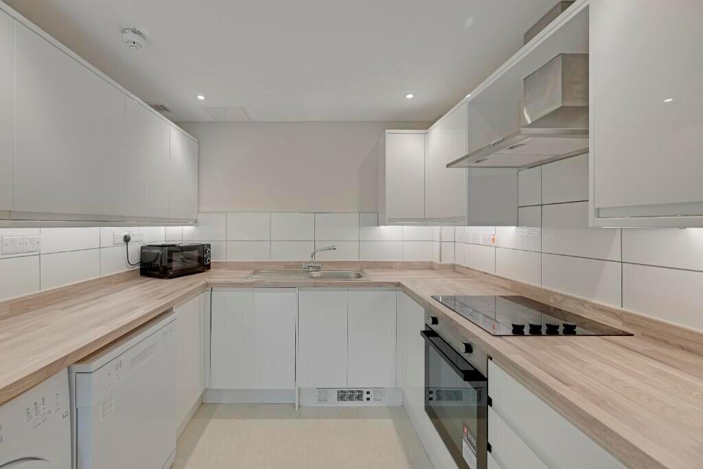 Modern kitchen with sleek white cabinetry and w...