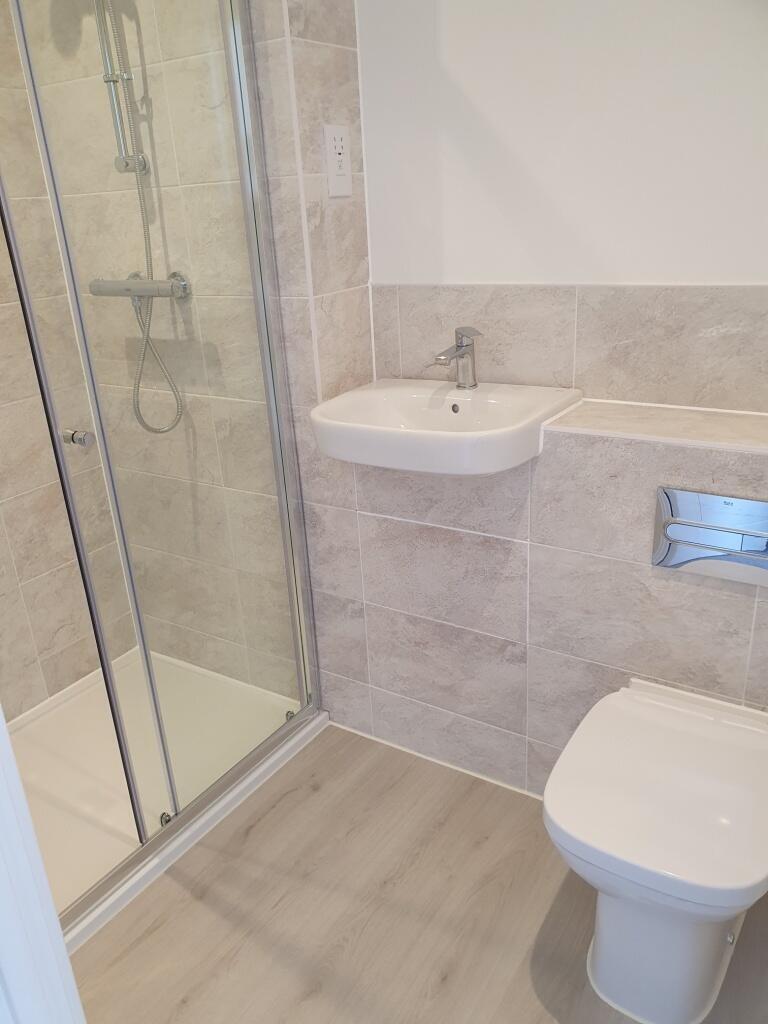 A modern bathroom featuring a spacious shower, ...