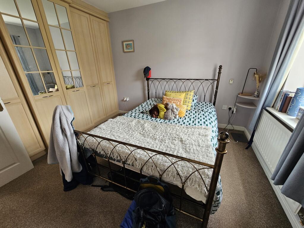 A cozy single bedroom featuring a neatly made b...