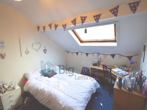 A cozy double bedroom with a comfortable bed, b...