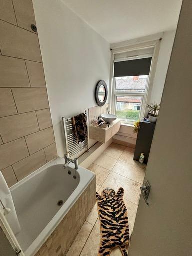 A bright, well-maintained bathroom with a batht...