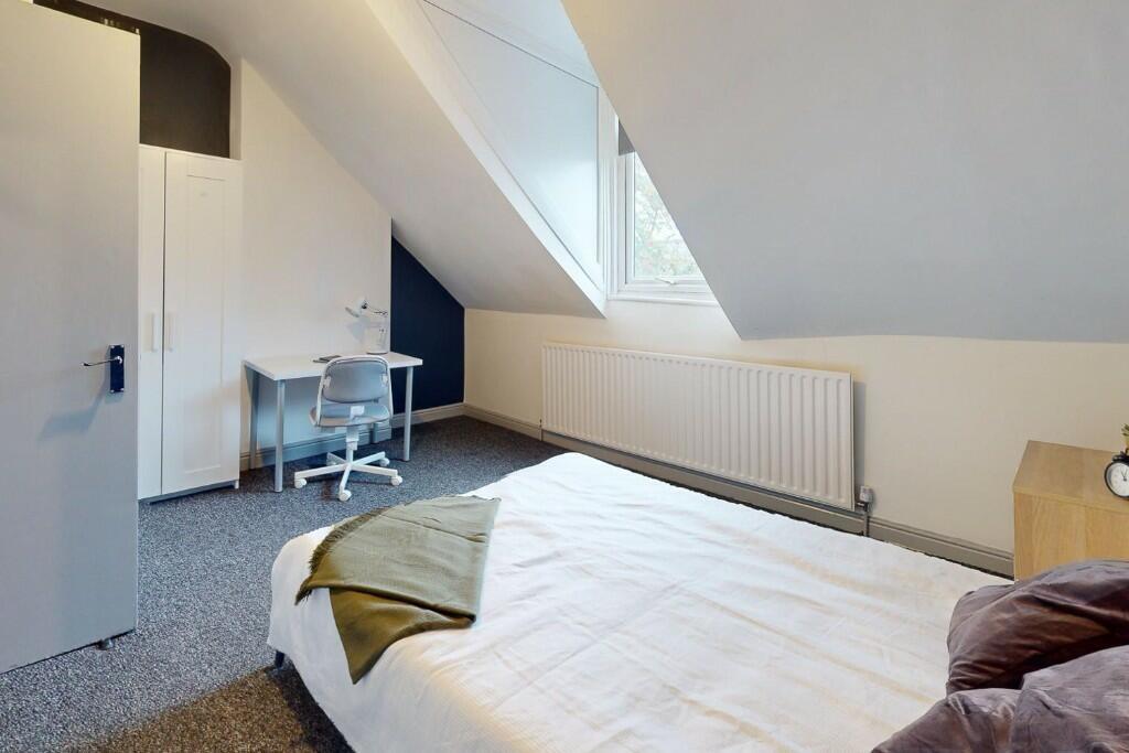 Bright and cozy bedroom featuring a comfortable...