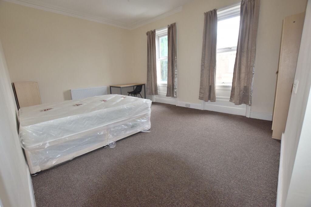 Bright, well-proportioned bedroom with two tall...