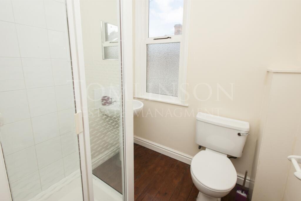 A bright and tidy bathroom featuring a shower, ...