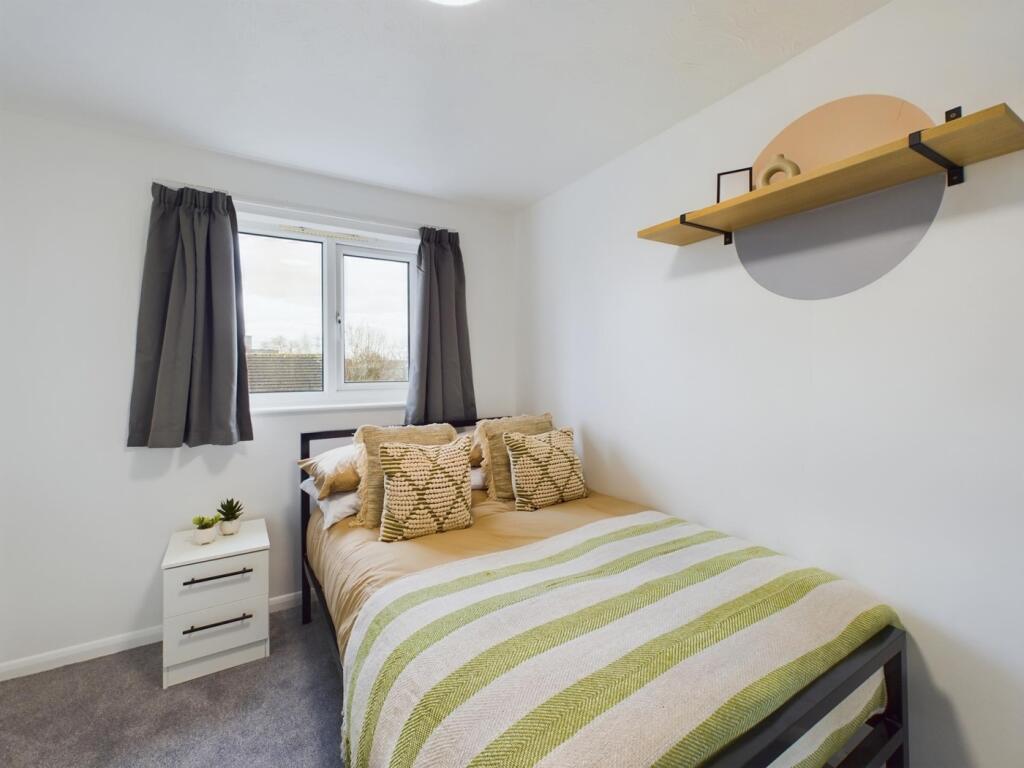 A bright and inviting double bedroom with styli...