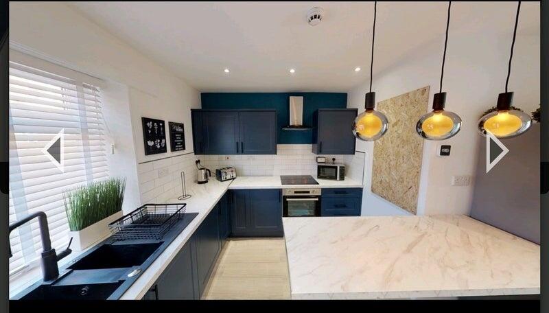 Bright and modern kitchen featuring sleek navy ...