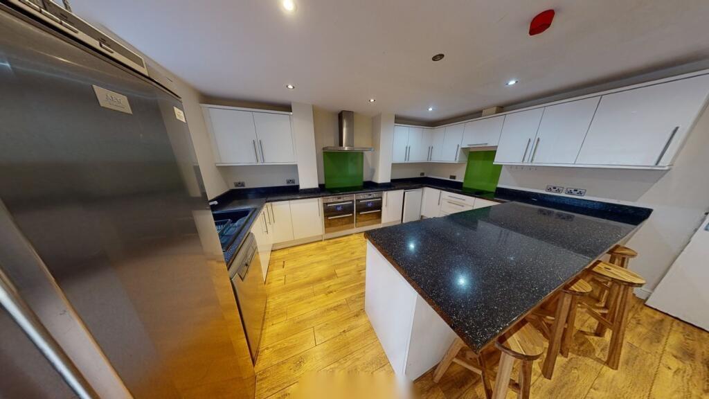 A modern, well-lit kitchen featuring a spacious...